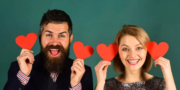 Pareja enamorada sostiene corazones sobre fondo gris verde. — Foto de Stock