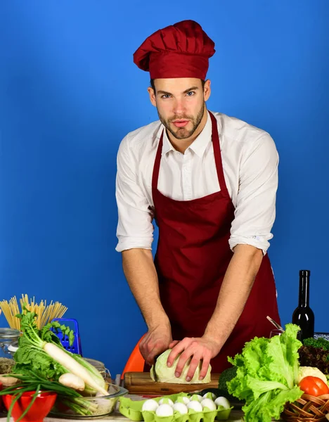 Cook arbetar i kök nära bord med grönsaker och verktyg. — Stockfoto