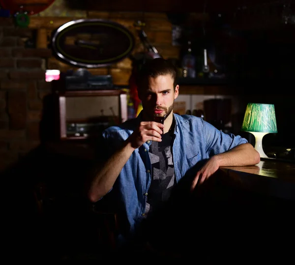 Szakállas férfi ül a bárban homályos háttér. — Stock Fotó