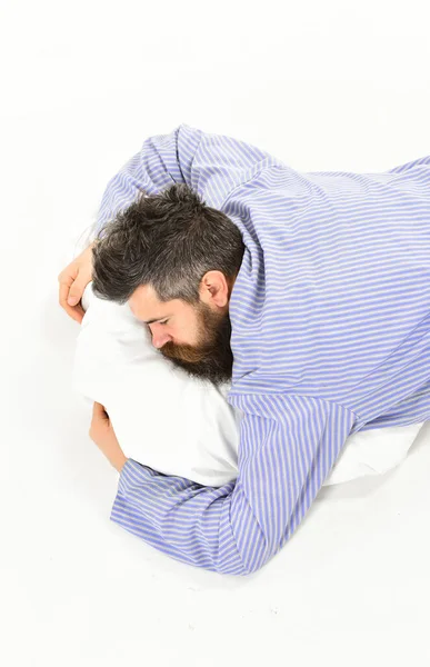 El hombre con la cara soñolienta yace en el vientre, abraza la almohada — Foto de Stock