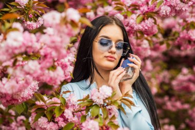 Tazelenmiş hissediyorum. Mutlu Paskalyalar. Zarif bir koku. Sabah bakımı. Parfüm arıyorum. Aromatik vücut losyonu. Seksi kadın parfüm şişesini tutuyor. Cilt bakımı kolajeni hyaluronik nem formülü tedavisi