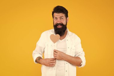 Sevgisini ifade ediyor. Romantik bir ruh hali. Uzun sakallı yakışıklı maço. Âşık ol. Sevgililer günün kutlu olsun. Kalbini tutan sakallı adam. Küçük kalpli bir hippi. Kalp şeklinde kartı olan sevgililer günü adamı.