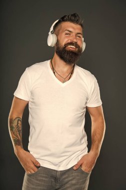 Mutlu ol. Mutlu hipster. Gri müzik dinle. Sakallı adam kulaklıkla çalan mutlu melodiyi sever. Mutlu ol ve müzik dinle. Zevk ve neşe. Eğlence ve eğlence