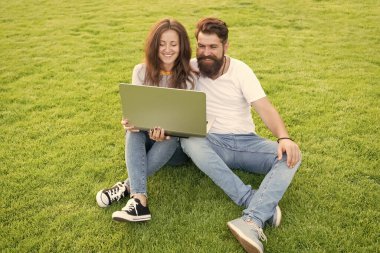 Bilgiye doğru. Parkta bilgisayarla çalışıyor. Adam ve kadın internette defter üzerinde sörf yapıyor. Öğrenci hayatı. İnternetten alışveriş. İletişim devrede. Mutlu çift yeşil çimlerde dizüstü bilgisayar kullanıyor.