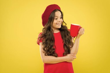 Kız çocuğu kupayı sarı arka planda tutar. Çocuk bardağı. Çay suyu kakaosu içiyorum. İçkiyle rahatlıyor. Gülümseyen çocuk içecek. Ev yapımı içki. En sevdiğin meyve suyu nedir? Yeterince su iç.