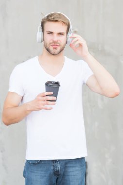 Afiyet olsun. Yakışıklı adam sıcak bardağı dışarıda tutuyor. Genç adam müzik dinlemekten hoşlanıyor. Sabah kahvaltısı ritüeli. Kafein enerjisi. İç ve keyfini çıkar. Kahveden sonra hayatın tadını çıkar