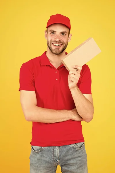 Postás kézbesítő. Férfi piros sapka sárga háttér. Vásárol. Boldogságot és szükségleteket teremteni. Szuper gyors futár ügynök. Szolgáltatásnyújtás. Üzletkötői karrier. Futár és kézbesítés — Stock Fotó