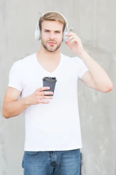 Disfruta de la comida para llevar. Un hombre guapo sostiene la taza caliente al aire libre. A los jóvenes les gusta la bebida escuchando música. Ritual de desayuno matutino. Energía de cafeína. Bebe y disfruta. Disfruta de la vida después del café — Foto de Stock