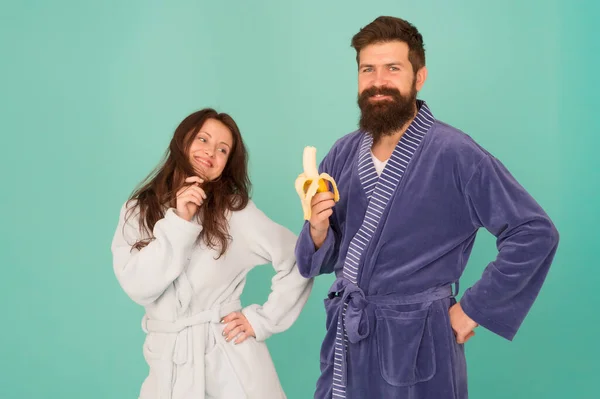 Healthy food. Couple sleepy faces domestic clothes eat banana. Couple in love bathrobes. Advice relationships surviving quarantine. Food for health. Healthy breakfast. Morning routine. Sharing food