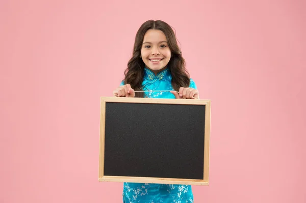 学校の広報。幸せな子供は黒板のピンクの背景を保持します。きちんとした広報板で小さな子供の笑顔。広告と宣伝。公共機関だ。学校のマーケティングキャンペーン、コピースペースに戻る — ストック写真