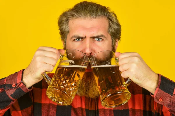 Beer with foam. Hipster drink beer. Mature bearded guy hold beer glass. Cheers toast. Holiday celebration. Fathers day. Birthday party concept. Alcoholic. Thirsty man drinking beer in pub bar