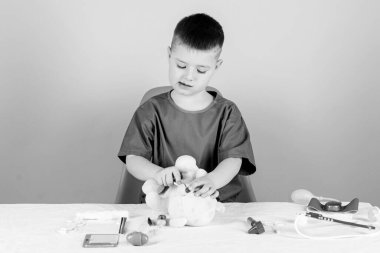 oyuncak tedavisi. Tedavi reçetesi. Çocuk doktoru stajyeri. Tıp üniformalı küçük bir çocuk. Hastane. İlaç ve sağlık. Hemşire laboratuvar asistanı. Aile doktoru. Steteskoplu çocuk doktoru.