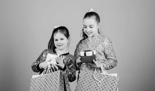 快乐的孩子们带礼品盒的小女孩销售和折扣。姐妹关系和家庭。采购节余。童装时尚。带包装的售货员。提购物袋的小女孩 — 图库照片