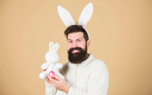 Homem vestindo terno de coelho brincar com brinquedo. Engraçado homem coelhinho orelhas macias. Conceito de atividades de Páscoa. Ainda é infantil. Comemore a Páscoa. Homem barbudo hipster coelhinho alegre com orelhas brancas longas. Coelho da Páscoa — Fotografia de Stock