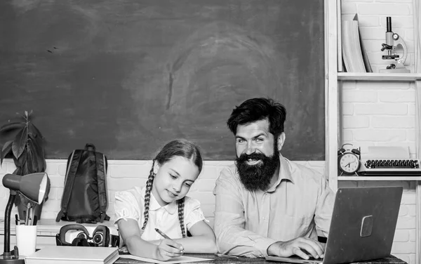 Private lesson. School teacher and schoolgirl with laptop. Study modern technologies. Homeschooling with father. Find buddy to help you study. Man bearded pedagogue teaching informatics. Study online