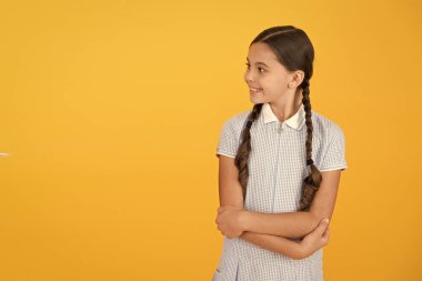 Okula geri dön. sarı arka plan üzerinde mutlu güzellik. mutlu çocukluk. saç sağlığı kavramı. uzun saçlı kız. vintage elbiseli akıllı kız. küçük kız retro üniforması. eski okul moda. kopyalama alanı
