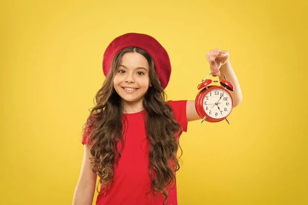 Controlling personal time. Schedule and time. Set up alarm clock. Child little girl hold red clock. Always on time. It is never too late. Everything is under control. Define own rhythm of life