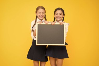 Bilgin olsun diye söylüyorum. Küçük çocuklar sarı arka plan hakkında bilgi almak için boş tahtayı tutuyorlar. Okul bilgisi için düzgün tahtaları olan küçük kızlar. Sizin için bilgi, kopyalama alanı