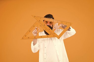 Ölçme aleti kullanan öğrenci. Mühendislik mimarlık fakültesi öğrencisi. Adam matematik dersi. Akıllı öğrenci. Üniversite eğitimi. Üçgenli sakallı. Özellikleri keşfetme