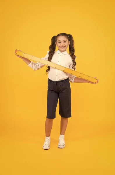 Geometry school subject. Education and school concept. Sizing and measuring. School student study geometry. Tell me about distance. Kid school uniform hold ruler. Pupil cute girl with big ruler