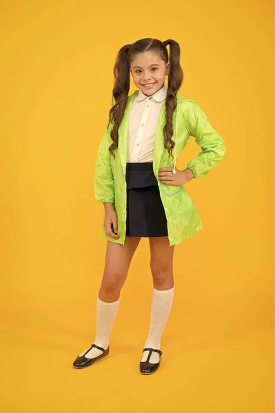 Αδιάβροχο αξεσουάρ. Παιδί κορίτσι ευτυχισμένο φορούν αδιάβροχο μανδύα. Απολαύστε ΦΘΙΝΟΠΩΡΙΝΟ καιρό με κατάλληλα ενδύματα. Αδιάβροχη αξεσουάρ κάνει βροχερή πτώση ημέρα χαρούμενο και ευχάριστο. Μαθήτρια σε πράσινο μανδύα — Φωτογραφία Αρχείου