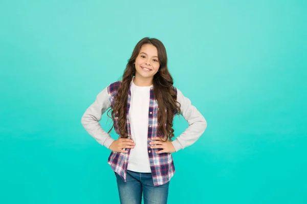 Viviendo una vida feliz. Concepto de buen humor. Vibraciones positivas. Emociones sinceras. Linda chica con el pelo largo. Niña de fondo turquesa. Camisa a cuadros de niña pequeña. Feliz día internacional de los niños —  Fotos de Stock