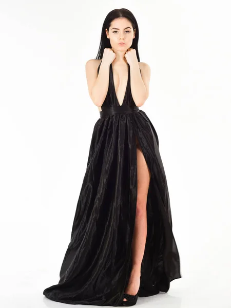 Senhora, menina sexy no vestido. Mulher em elegante vestido de noite longo preto com decotado, fundo branco. Menina atraente usa vestido de noite elegante caro com fenda erótica. Conceito de vestido moda — Fotografia de Stock