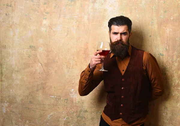 Человек с бородой держит бокал вина — стоковое фото