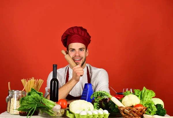 Aşçı şapkalı ve önlüklü adam yemek yapmaya hazırlanıyor. — Stok fotoğraf