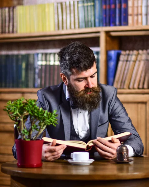 Relax, pleasure, leisure, hobby concept. Bearded man in luxury suit in public library.