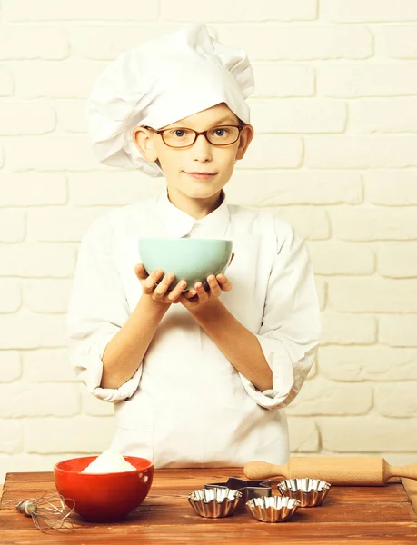Gülümseyen çocuk tuğla duvarda aşçı şefi — Stok fotoğraf