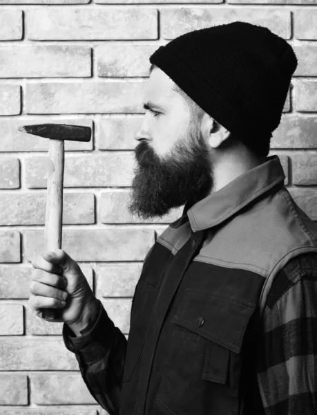 Бородатий будівельник тримає молоток серйозне обличчя — стокове фото