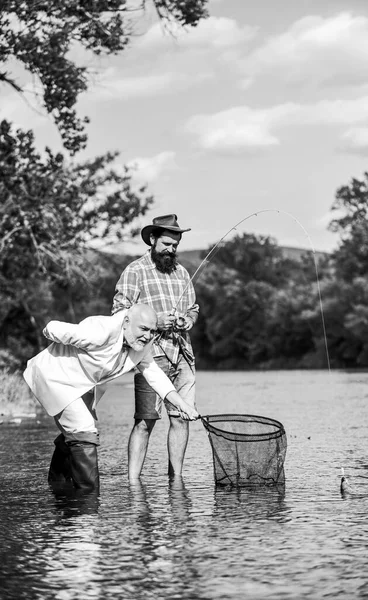 Pace della mente e tranquillità. Pesce d'acqua dolce. Giornata attiva. Amici che pescano pesce. Hobby e tempo libero. Prendere il pesce con anima gemella. Uomo barbuto e brutale pesca hipster. Giornata di famiglia. Equipe di pesca — Foto Stock