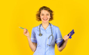 Senin için en iyi tedavi. Hemşire klasörü tutuyor ve steteskop takıyor. Üniformalı bir dosyayla gülümseyen kadın doktor. Dosyası olan sevimli bir hemşirenin portresi. Steteskop takıyor.