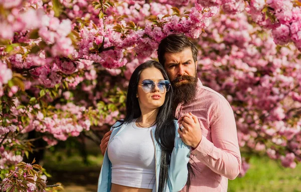 Dia da Primavera. Adorável homem e mulher barbudos no parque primaveril. Apaixonado. casal apaixonado lá fora na natureza primavera, abraçando. Homem e mulher no jardim florescente. Casal perto da árvore sakura. amor e união — Fotografia de Stock