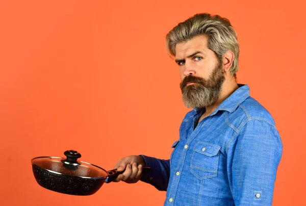 Qui se soucie de l'alimentation. culinaire et gastronomique. Des ustensiles de cuisine. Cuisine saine. cuisine plat savoureux. homme barbu tenir poêle à frire. Cuisiner dans la casserole. pour la préparation des aliments. Barbu homme cuisine dans la cuisine — Photo