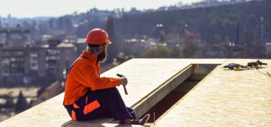 Isı yalıtımı. Profesyonel tamir çatısı. Düz çatı kurulumu. Roofer yeni çatı yapıyor. Çatıda adam var. Projeler için tahmini malzeme gereksinimleri. Çatı malzemeleri yükle