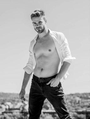 Kaslı gövde. Kaslı seksi maço adam. Çekici gövde. Açık havada sıcak bir gün. Çekici bir adamın gömleğini çıkarması. Cazibesine güveniyor. Sakallı adam iş stili. Yakışıklı erkek manken.