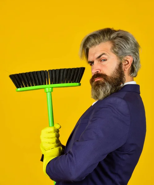 On guard of order. Cleaning day. Cleaning business. Household duties. Cleaning service concept. Clear reputation. Bearded man formal suit hold broom brush. Sweep in office. Hipster enjoy cleanliness