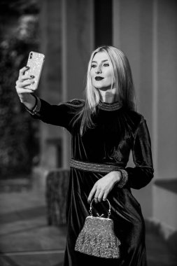 Yeni tarzını seviyor. Moda blogu. Zarif yeşil kadife elbise. Cazip kadife tekstil. Seksi iş kadını telefonda selfie çekiyor. Modern hayat. Kızlar için değerli taş bir çanta. glam debriyaj aksesuarı