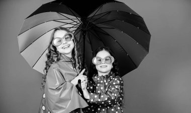 Birlikte mutlu olmak daha kolay. Bulutlarda gökkuşağı ol. Şemsiyenin altında yürü. Çocuklar şemsiye altında mutlu arkadaşlar. Yağmurlu hava ve uygun giysiler. Parlak şemsiye. Mutlu çocukluk