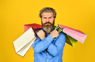 En iyi satış ve indirim burada. Tatil için hediyeler. Yetişkin bir hippi alışveriş çantası taşır. Siber pazartesi ya da kara cuma. Satın aldığınız için teşekkürler. Alışveriş yaptıktan sonra sakallı ciddi bir adam. Hepsini alıyorum.