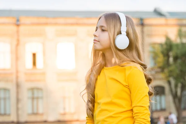 Słuchasz mnie uważnie? Małe dziecko słucha muzyki na świeżym powietrzu. Mały słuchacz nosi słuchawki. Słuchanie. Relaks i słuchanie. Współczesne życie. Poczuj muzykę słuchasz — Zdjęcie stockowe