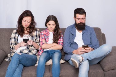 Teknoloji aileyi çocuktan uzaklaştırıyor. Küçük çocuk ve ebeveynler telefona bakarlar. Evde mutsuz bir çocuk ve aile var. Ebeveynlik ve çocukluk. Çocuk bakımı. Çocukla ilgilenmek