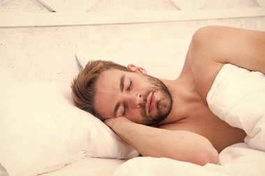 Uyanma ve güzel bir gün geçirme zamanı. Günaydın. Tatlı rüyalar. Erkek sağlığı ve bekar yaşam tarzı. Adam derin uykuda. Yatak odasında rahatla. Enerji ve yorgunluk. Sabah seksi konsepti. Seksi adam yatakta uyuyor.