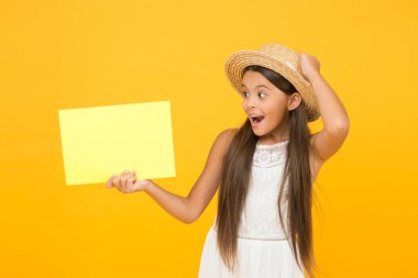 Boş kağıtlı, tropik zarif bir kız. kopyalama alanı. Sarı arka planda hasır şapkalı mutlu kız. Romantik kız gezginlerin aksesuarları. Retro çocuk sürpriz yaptı. duyuru ve bilgi