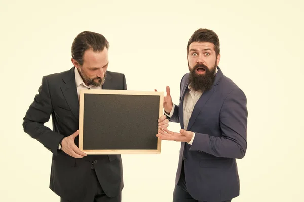 Informations intéressantes. Un bel homme d'affaires tient un tableau noir. Célébration des réalisations. Entrepreneurs prospères. Académie de commerce. Concept de gens d'affaires. Les hommes barbus portent des vêtements formels — Photo