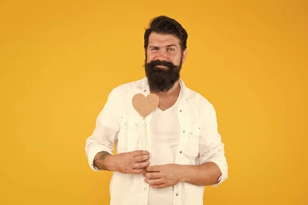 Feliz Dia dos Namorados. Homem barbudo a segurar o coração. Hipster com coração pequeno. Valentim homem com cartão em forma de coração. A expressar o seu amor. Humor romântico. Bonito macho com barba comprida. Apaixone-se — Fotografia de Stock