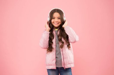 Çok modaya uygun görünüyorsun. Kulaklıkla çalan eğlenceli şarkı. Karaoke ve eğlence. Bir şarkıya katılıyorum. Küçük kız pembe arka planda şarkı söylüyor. Küçük çocuk şarkıda vokal yapıyor. Duygusal şarkıcı.