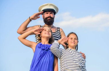 Yaz yolculuğu konsepti. Mutlu bir aile. Baba denizci ve kızları dışarıda. Kaptan aramıza hoş geldin. Deniz turu. Deniz gezisi. Çocuklu yakışıklı sakallı denizci. Dünyayı dolaş. Deniz yoluyla seyahat et.